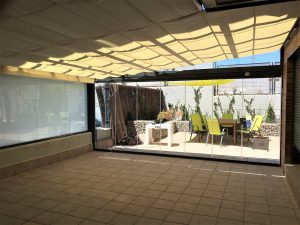 Toldo garden bajo techo de cristal